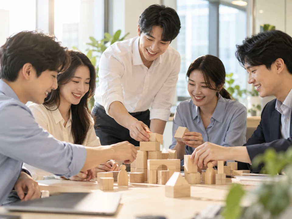 목재 블록을 함께 쌓으며 협업하는 팀원들